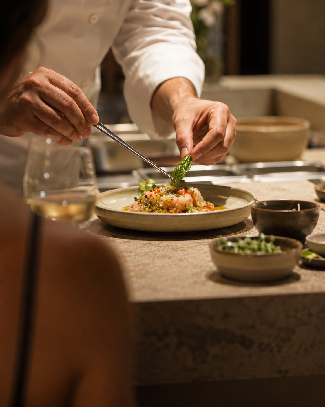 Manos del chef trabajando frente a los invitados